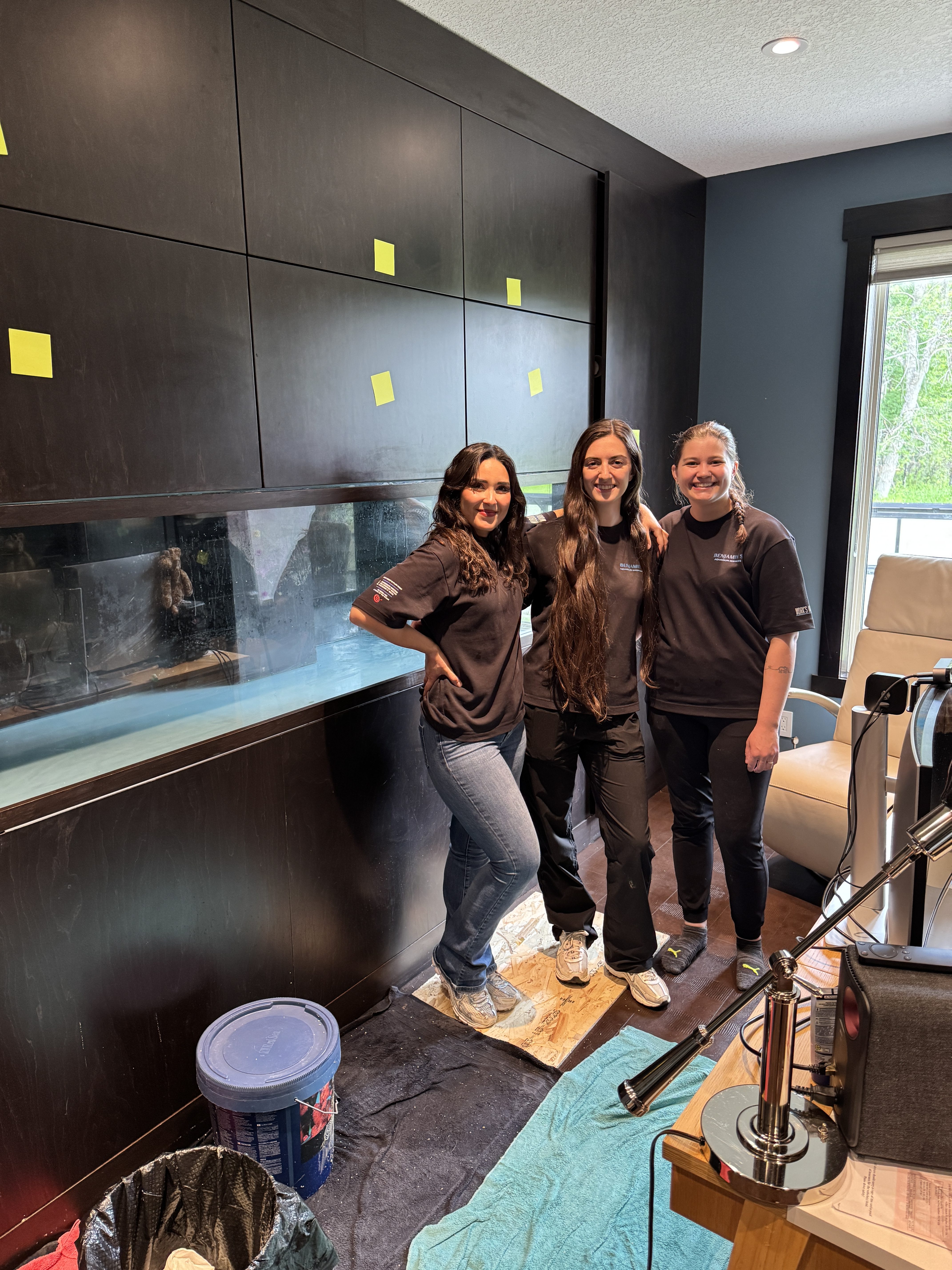 Custom aquarium installation team standing beside a handcrafted custom aquarium and cabinetry project in Calgary